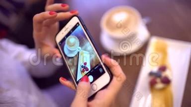 餐馆里的女人用手机相机拍食物。 把手拿上智能手机拿着食物